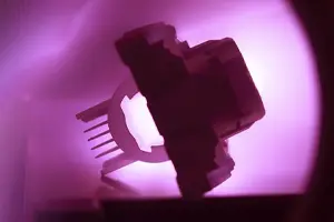 Image of a component being cleaned in a plasma chamber
